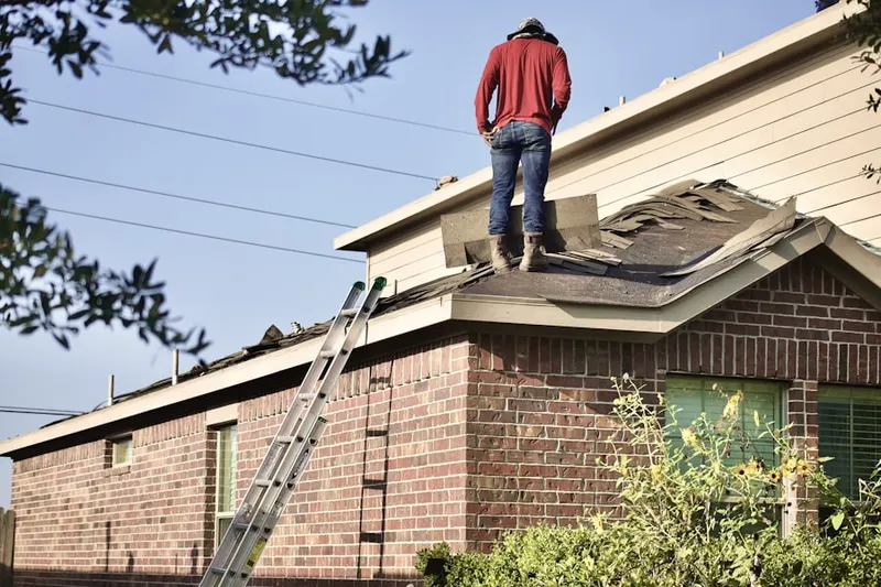 Professional roofer working on a residential roof in De Graff